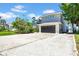 Two-story modern home showcasing a long driveway and a spacious attached two car garage at 915 Bayshore Dr, Tarpon Springs, FL 34689