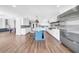 Spacious white kitchen with a blue island, stainless steel appliances, and hardwood floors at 915 Bayshore Dr, Tarpon Springs, FL 34689