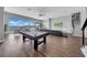 Bright living room with a pool table, large windows with waterfront view, and adjacent seating areas at 915 Bayshore Dr, Tarpon Springs, FL 34689