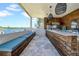 Outdoor kitchen overlooking the waterway, featuring custom wood cabinets and bar top seating at 915 Bayshore Dr, Tarpon Springs, FL 34689