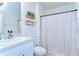 Bathroom featuring a vanity, open shelving, toilet, and shower with patterned curtain at 10555 Penny Gale Loop, San Antonio, FL 33576