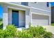 Home exterior with a blue front door, a two-car garage, and landscaping at 10555 Penny Gale Loop, San Antonio, FL 33576