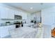 Modern kitchen with white cabinetry, stainless appliances, and granite countertops at 10555 Penny Gale Loop, San Antonio, FL 33576