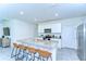 Modern kitchen with white cabinets, granite countertops, an island with seating, and stainless steel appliances at 10555 Penny Gale Loop, San Antonio, FL 33576