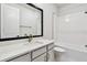 Modern bathroom featuring sleek white subway tiles, a tub, and a stylish vanity with gold fixtures at 11834 Mile Marsh Dr, Riverview, FL 33569