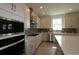 Modern kitchen featuring white cabinets, a stainless steel hood, and a center island at 11834 Mile Marsh Dr, Riverview, FL 33569