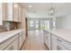 Bright kitchen featuring stainless steel appliances, stylish tile backsplash, and a quartz countertop island at 11834 Mile Marsh Dr, Riverview, FL 33569