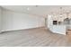 Bright open-concept living room with gray wood floors flowing into a modern kitchen with stainless steel appliances at 11834 Mile Marsh Dr, Riverview, FL 33569
