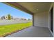 Covered patio with concrete flooring overlooking manicured lawn and white fence at 11834 Mile Marsh Dr, Riverview, FL 33569