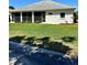 Well-maintained backyard with lush green grass, a screened-in patio, and manicured landscaping at 1201 Ventana Dr, Sun City Center, FL 33573