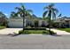 Charming single-story home with a manicured lawn, elegant landscaping, and a welcoming two-car garage at 1201 Ventana Dr, Sun City Center, FL 33573