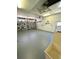 Clean, empty garage featuring an automatic door opener, ample storage space, and a side entry door at 1201 Ventana Dr, Sun City Center, FL 33573