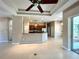 Open-concept living space featuring tile floors, decorative columns, and seamless flow to the kitchen at 1201 Ventana Dr, Sun City Center, FL 33573