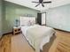 Bedroom featuring a ceiling fan, hardwood floors, and a comfortable bed with lamps at 1221 E Emma St, Tampa, FL 33603