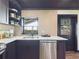 Modern kitchen featuring stainless steel appliances, white countertops, and dark cabinets at 1221 E Emma St, Tampa, FL 33603