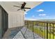Balcony with views of the ocean and tennis courts with metal railing and a ceiling fan at 1230 Gulf Blvd # 508, Clearwater Beach, FL 33767