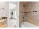 Bright bathroom featuring a combined shower and tub with decorative tile accents and granite countertop sink at 1230 Gulf Blvd # 508, Clearwater Beach, FL 33767