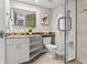Bathroom with frameless shower, granite countertop sink, modern faucet, toilet and white storage shelves at 1230 Gulf Blvd # 508, Clearwater Beach, FL 33767