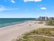 Coastal view of a beautiful beach with soft sand, beach goers and calm ocean waters under a sunny sky at 1230 Gulf Blvd # 508, Clearwater Beach, FL 33767