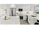 Modern white kitchen featuring stainless steel appliances, quartz countertops, and bright natural light at 1230 Gulf Blvd # 508, Clearwater Beach, FL 33767