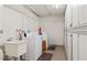 Functional laundry room with modern washer and dryer units, a utility sink, and convenient storage lockers at 1230 Gulf Blvd # 508, Clearwater Beach, FL 33767