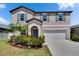 Two story home with blue shutters, manicured landscaping, and a two car garage at 13234 Great Plains Dr, Riverview, FL 33579