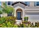 Charming entryway with an arched alcove, blue door, and lush landscaping at 13234 Great Plains Dr, Riverview, FL 33579