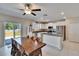 Modern kitchen features white cabinetry, stainless steel appliances, an island with granite countertops, and a view of the backyard at 13234 Great Plains Dr, Riverview, FL 33579