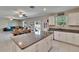 Open-concept kitchen features an island with granite countertops, white cabinets, and seamless integration with the living area at 13234 Great Plains Dr, Riverview, FL 33579