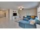 Open concept living room featuring a plush blue sectional and neutral color palette at 13234 Great Plains Dr, Riverview, FL 33579