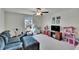 Bright living room featuring a comfortable blue sofa, ceiling fan, and plenty of space for play at 13234 Great Plains Dr, Riverview, FL 33579