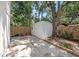 A white shed in the backyard, with a small patio and mature tree at 1557 Robinson N Dr, St Petersburg, FL 33710
