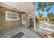 Close-up of the covered front entrance with stone accents, a decorative door, and a tidy landscape at 1557 Robinson N Dr, St Petersburg, FL 33710