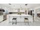 Modern kitchen featuring white cabinets, quartz island, stainless steel appliances, and decorative backsplash at 1557 Robinson N Dr, St Petersburg, FL 33710