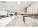 Bright kitchen with white cabinets, quartz countertops, mosaic backsplash, and modern lighting at 1557 Robinson N Dr, St Petersburg, FL 33710