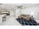 Cozy living room with a comfortable sectional sofa, ceiling fan, decorative rug, and marble floors at 1557 Robinson N Dr, St Petersburg, FL 33710