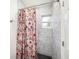 This bathroom includes a shower with a floral curtain, hexagon floor tiles, and marble wall tiles at 1557 Robinson N Dr, St Petersburg, FL 33710