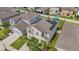 Aerial view of a neighborhood showcasing a two-story home with solar panels and a well-manicured lawn at 17331 White Mangrove Dr, Wimauma, FL 33598