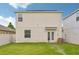 Well-kept backyard featuring a green lawn, white fence, and the home's exterior with solar panels at 17331 White Mangrove Dr, Wimauma, FL 33598