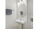 Clean half bath with a pedestal sink, oval mirror, and neutral decor at 17331 White Mangrove Dr, Wimauma, FL 33598