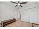 Well-lit bedroom with light wood floors, a ceiling fan, closet and doorway at 17331 White Mangrove Dr, Wimauma, FL 33598