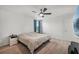 Bright bedroom with ceiling fan, wood floors, and a window provides natural light at 17331 White Mangrove Dr, Wimauma, FL 33598