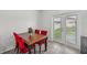 Cozy dining area features a wooden table, red chairs, and a view of the backyard through glass doors at 17331 White Mangrove Dr, Wimauma, FL 33598