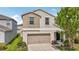 Charming two-story home featuring tan exterior, a two-car garage and manicured front lawn at 17331 White Mangrove Dr, Wimauma, FL 33598