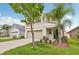 Charming two-story home featuring tan exterior, a two-car garage and landscaped front lawn at 17331 White Mangrove Dr, Wimauma, FL 33598