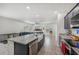 Open kitchen view showing a granite island with a farmhouse sink and view of the living room at 17331 White Mangrove Dr, Wimauma, FL 33598
