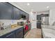 Kitchen with stainless steel appliances, granite counters, and ample navy blue cabinetry at 17331 White Mangrove Dr, Wimauma, FL 33598