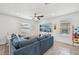 Bright living room featuring a sectional sofa, ceiling fan and large windows for natural light at 17331 White Mangrove Dr, Wimauma, FL 33598