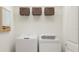 Well-lit laundry room with a washer, dryer, storage shelf and a neutral color scheme at 17611 Happytrails St, Land O Lakes, FL 34638