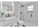 Updated bathroom featuring sleek vanity, glass-enclosed shower with rainfall shower head and window at 19 Crescent S Pl, St Petersburg, FL 33711